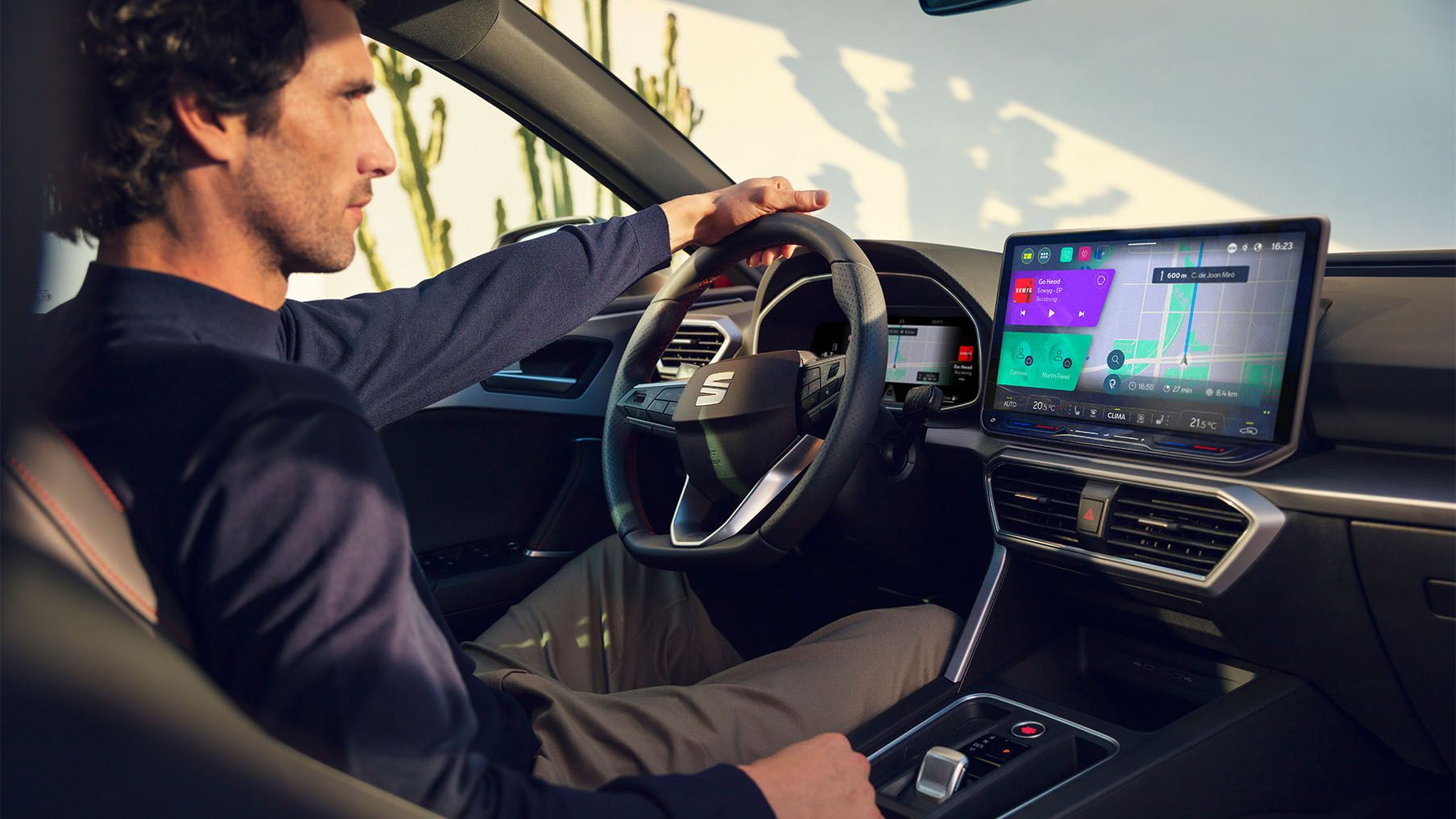 Innenraumansicht wie ein Mann in einem SEAT Leon sitzt und das Navigationssystem am Bildschirm nutzt